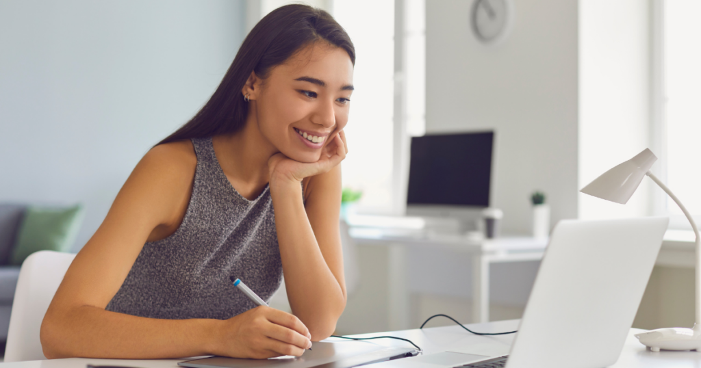 The Pros and Cons of DIY Website Builders vs. Custom Web Design 1 Smiling woman building a website using a DIY website builder on a laptop