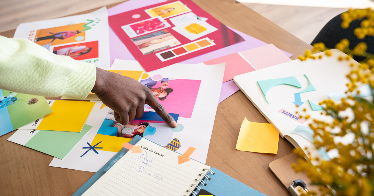 Creative hand pointing to mood board with color swatches and branding visuals during design meeting